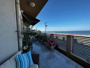 a balcony with a couch and a view of the beach at Vila Aquamarine in Eforie Nord