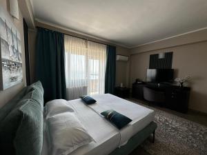 a bedroom with a large bed and a large window at Vila Aquamarine in Eforie Nord
