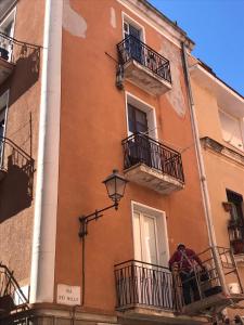 dwie osoby stojące na balkonie budynku w obiekcie casa SorrisiEsoGni w Cagliari