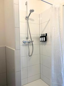 a bathroom with a shower with a shower curtain at Apartment Ratingen - Balkon, Nähe DÜ-Messe und Airport in Ratingen +7 photos