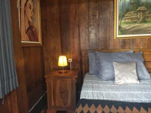 een slaapkamer met een bed en een lamp op een nachtkastje bij Bujak Permai Villa Matahari Lombok NTB in Praya