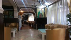 a waiting room with chairs and a table and curtains at Mevlana Hotel in Konya