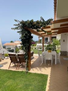 a patio with a table and a pergola at Villa Sofia *Luxury experience in Calabria in Zambrone
