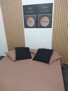 a white bed with two pillows on top of it at Hostel da Maisa Quarto casal com ar condicionado e banheiro compartilhado in Barreiras