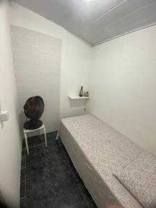 a bedroom with a bed and a chair in it at Hostel da Maisa Quarto casal com ar condicionado e banheiro compartilhado in Barreiras