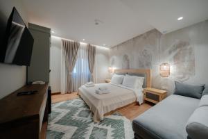 een slaapkamer met twee bedden en een flatscreen-tv bij Vintage Boutique Hotel in Korçë