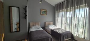 two twin beds in a room with a window at Sejf House in Gdańsk