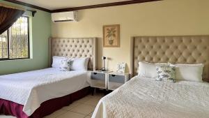 een slaapkamer met 2 aparte bedden en een raam bij Villa Noelia in El Jurón