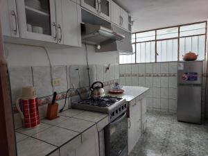 a kitchen with a stove and a refrigerator at Pawllu Inqa Lodge in Cusco