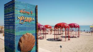 a beach with a bunch of red umbrellas on it at Villa NIAN Boutique in Constanţa