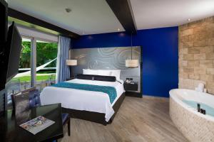 a bedroom with a king sized bed and a bath tub at Hard Rock Hotel Riviera Maya- Heaven Section (Adults Only) All Inclusive in Puerto Aventuras