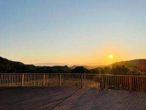 a wooden deck with the sunset in the background at Panorama Paradiso by CasadeLuz, 5Acre 360 Retreat close to Old Town Temecula Wine Country in Temecula