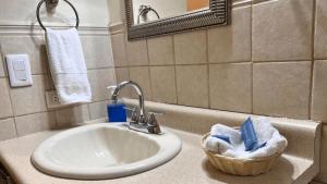 een wastafel in de badkamer met een mand met handdoeken en een spiegel bij Villa Noelia in El Jurón +89 foto's