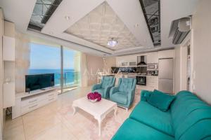 ein Wohnzimmer mit einem blauen Sofa und einem Tisch in der Unterkunft Calista, Empire, Seven Stars Residence in Alanya