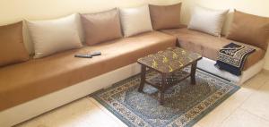 a brown couch with a table in a room at hôtel mamounia el hajeb in El Hajeb