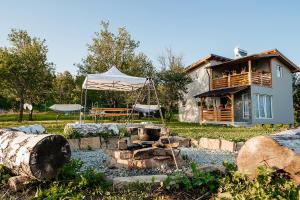 a house with a tent in front of a yard at Cabana Allegro in Moisei