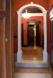 Appartamento Ca' Cavalli في البندقية: مدخل إلى مدخل مع جدران حمراء وممشى