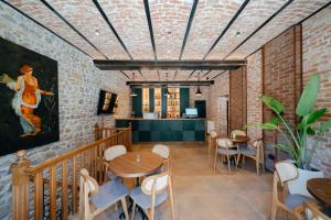 een restaurant met een bakstenen muur en tafels en stoelen bij Vintage Boutique Hotel in Korçë