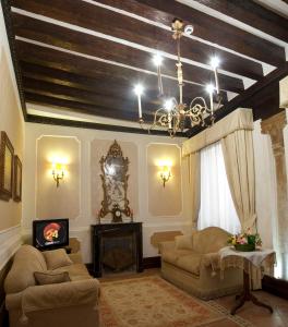Appartamento Ca' Cavalli في البندقية: غرفة معيشة مع أريكة وثريا