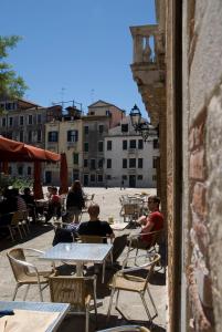 a group of people sitting at tables in a patio at Appartamento Ca' Cavalli in Venice