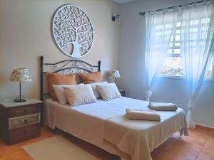 a bedroom with a bed with a tree picture on the wall at El Zumacalito in Breña Baja