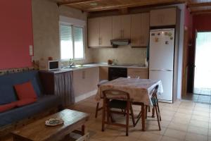 a kitchen with a table and a white refrigerator at La Traviesa in Soneja
