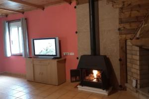 a living room with a fireplace and a television at La Traviesa in Soneja