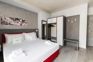 a bedroom with a large white bed and a cabinet at CORSO49 Boutique Rooms in Civitanova Marche