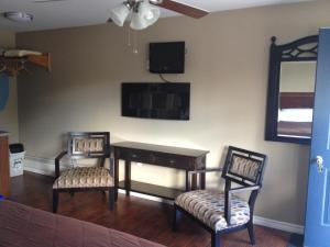 a room with a desk and two chairs and a mirror at My Friends Inn Manitoulin in Manitowaning