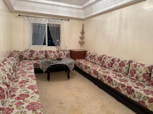 a living room with a couch and a table at Chez Mamie Kenza in Mohammedia +2 photos