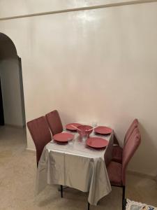 a table with red plates and glasses on it at Chez Mamie Kenza in Mohammedia