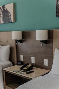 a hotel room with a bed and a table with two lamps at Hampton Inn By Hilton Celaya in Celaya