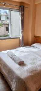 a bedroom with a large bed with a window at Tourist Apartment Baluwatar in Kathmandu