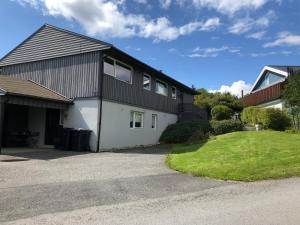 a black and white house with a driveway at Leilighet i Drøbak, rolig sted nær golfbane og fine turstier in Husvik