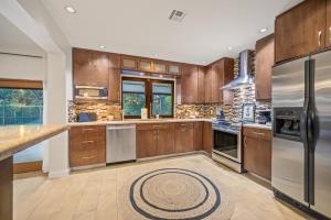 eine Küche mit Holzschränken und Geräten aus Edelstahl in der Unterkunft Family Beach Home With Home Theater & Heated Pool! in Hollywood