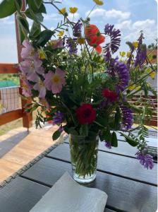 a vase filled with flowers sitting on a table at Casuta MARI in Săldăbagiu de Munte