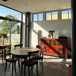 a dining room with two tables and a red cabinet at La Maison Du Coteau in Cachan