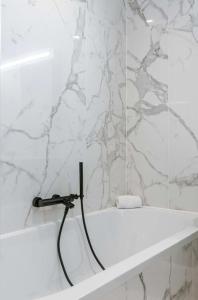 e bagno con vasca e tubo nero. di Poseidon Luxe gelijkvloers appartement met tuin ,terras en gratis parking a Knokke-Heist Altre 13 foto