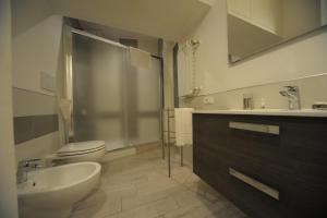 Un baño con lavabo, inodoro y espejo. en Bbrothershouse, en Roma
