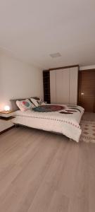 Un dormitorio con una cama y suelo de madera. en Loft Granda Centeno, en Quito