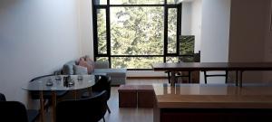 sala de estar con 2 mesas y ventana grande en Loft Granda Centeno, en Quito