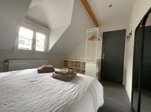 a bedroom with a bed with two towels on it at Chambres d'hôtes à 30 min de Paris in Maisons-Laffitte +2 photos