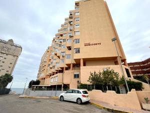a white car parked in front of a building at Pequeno paraiso in Ifach