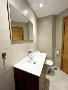 a bathroom with a sink and a toilet and a mirror at Pequeno paraiso in Ifach +4 photos