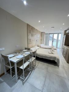 a bedroom with a bed and a table and chairs at Pequeno paraiso in Ifach