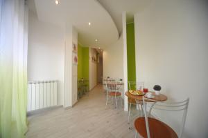 comedor con mesa, sillas y paredes verdes en Bbrothershouse en Roma