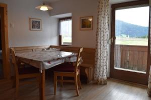 a dining room with a table and chairs and a window at Ferienwohnungen Bulandhof in Valdaora