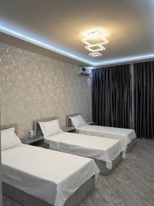タシュケントにあるTownHouse Near To Tashkent Terminal 3のベッド2台とシャンデリアが備わるホテルルームです。