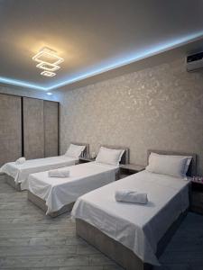 タシュケントにあるTownHouse Near To Tashkent Terminal 3のホテルルーム 白いシーツ付きのベッド2台付