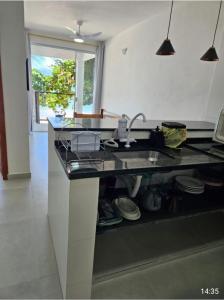a kitchen with a sink and a counter top at Chalés Pé na Areia - Ubatuba in Ubatuba